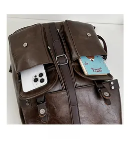 Gros plan des poches avant sur sac à dos vintage en similicuir marron avec boucles aimantées
