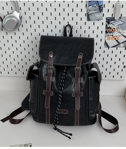 Close-up of black faux leather vintage backpack with brown straps and white stitching