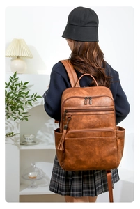 Caramel vintage leather backpack with three-tier zipper pockets and tassel detail