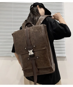 Close-up of retro dark brown leather backpack with silver buckle and flap cover