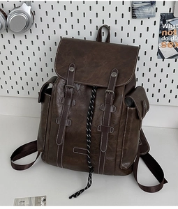 Detail view of vintage dark brown faux leather backpack with buckle and drawstring closure