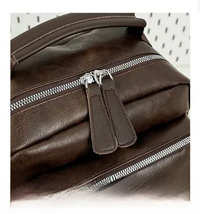 Detail of smooth metal zipper and premium leather texture on brown vintage backpack