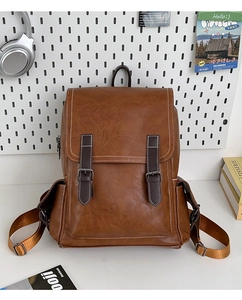 Detail view of brown PU leather backpack with vintage buckles and contrast stitching
