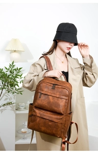 Sac à dos vintage en cuir PU marron avec plusieurs poches zippées et détails métalliques
