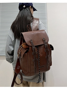 Side view of a vintage dark brown leather backpack on a model showing buckle details