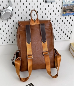 Close-up of brown vintage leather backpack showing adjustable straps and white stitching