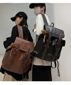 Detail view of vintage PU leather backpacks in brown and black with bear charms