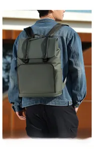 Rear view of a dark green leather business backpack worn by a male model in an urban setting