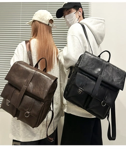 Dettaglio di zaini vintage in pelle marrone e nero con fibbie metalliche lucide