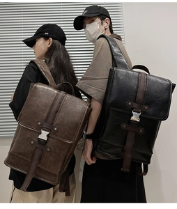 Detail view of vintage synthetic leather backpacks in brown and black with silver buckles