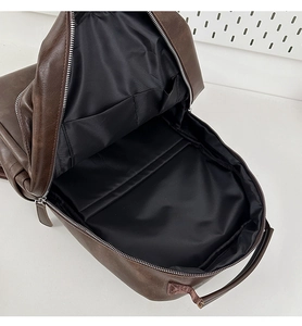 Internal view of brown vintage backpack showing black fabric lining and storage pockets