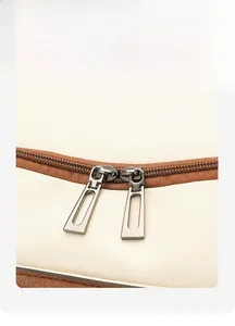 Macro shot of durable silver dual zippers on high-quality white pebbled leather backpack