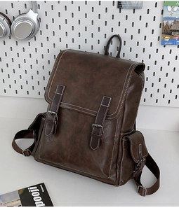 Detail of dark brown retro PU leather backpack with side pockets and contrast stitching