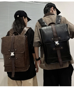 Rear view of vintage black and brown leather backpacks with metal buckles and flap design
