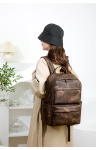 Détails d'un sac à dos vintage marron foncé avec plusieurs poches zippées et bretelles larges