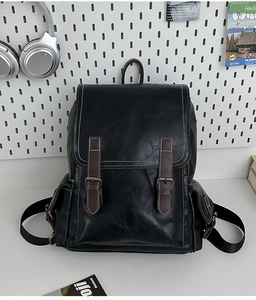 Close-up of black PU leather backpack with contrast white stitching and brown buckle details