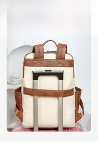 Detail view of beige and brown backpack with back sleeve for suitcase handles