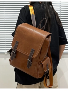 Detail of retro brown PU backpack featuring contrast white stitching and wide orange straps