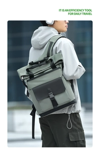 Outdoor shot of a man wearing the grey-green and black urban roll-top commute backpack