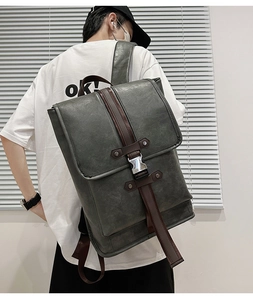 Rear view of a man wearing a large vintage leather backpack with dark grey and brown accents