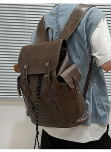 Detail of vintage brown PU leather backpack with contrast stitching and buckle straps