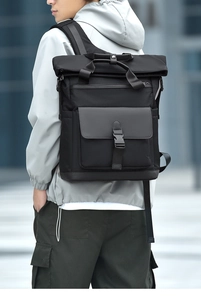 Side view of a large black business backpack for men showing padded straps and buckled flap