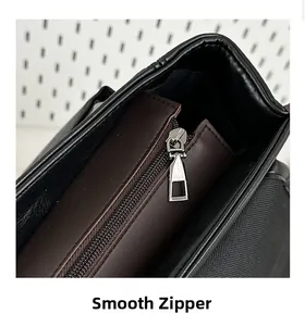 Detail of smooth silver metal zipper on premium black leather backpack with brown lining