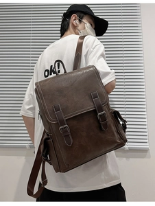 Detailed close-up of brown PU leather backpack featuring vintage strap buckles and side pockets