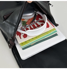 Top view of spacious interior showing laptop, magazines and headphones in black backpack
