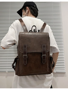Close-up of retro PU leather backpack with vintage buckles and contrast stitching detail
