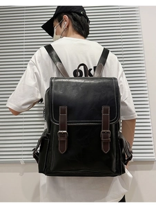Detail shot of vintage black PU leather backpack with brown straps and contrast stitching