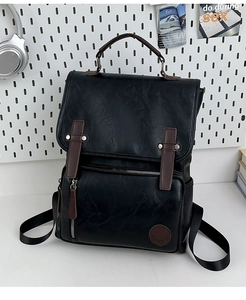 Detailed macro view of retro black PU leather backpack with brown buckle straps and side pocket