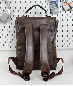 Detail of vintage brown PU leather backpack with luggage strap and padded shoulder straps