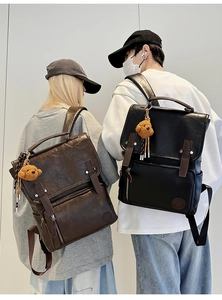 Detail of retro PU leather backpacks with flap closure and cute bear charms for men and women