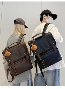 Detail view of large PU leather backpack featuring buckled flap and side pockets