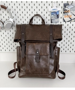 Detail view of the vintage brown PU leather backpack with buckle straps and side pockets