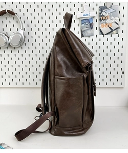 Side view of dark brown PU leather backpack showing functional side pocket detail
