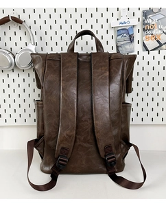 Detail view of the padded back and adjustable straps on a vintage brown leather backpack