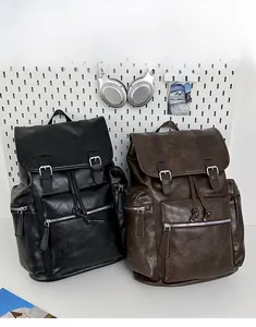 Detail of vintage PU leather backpacks in black and brown with twin buckle straps