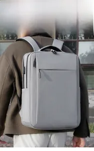 Outdoor shot of light gray business backpack featuring USB charging port and side pocket