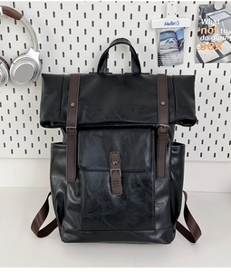 Detail of vintage black PU leather backpack with brown buckle straps and large main compartment