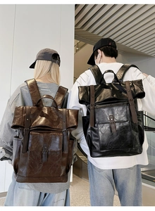 Detailed street style shot of vintage PU leather backpacks in black and brown finishes