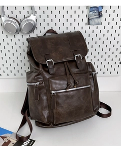 Detail of vintage brown leather backpack with strap buckles and drawstring closure