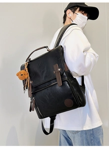 Black PU leather backpack with a plush bear charm shown in a stylish side view for commuters