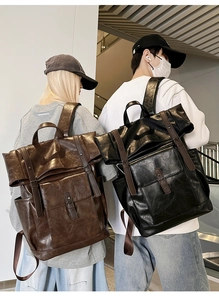 Detail of vintage PU leather backpacks in brown and black showing flap and buckle design