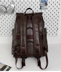 Detail view of brown faux leather backpack straps and side pocket in a lifestyle setting