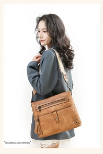 Brown vintage shoulder bag with multiple zippers and ethnic woven strap detail