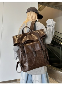 Detail of vintage dark brown PU leather backpack with buckle straps and flap pockets