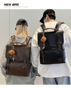 Close-up of vintage PU leather backpack with flap closure and cute plush bear charm