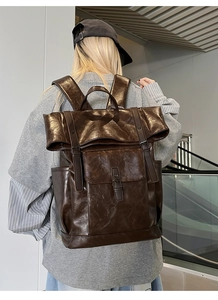 Close-up of vintage brown PU leather backpack with buckle detail and textured finish
